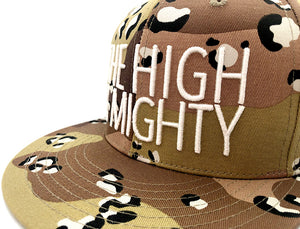 tan camouflage hat with writing The High & Mighty on front