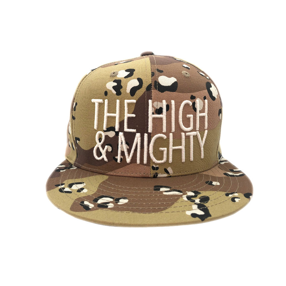 tan camouflage hat with writing The High & Mighty on front